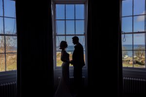 Bride and groom standing by the bay window in the Bridal suite